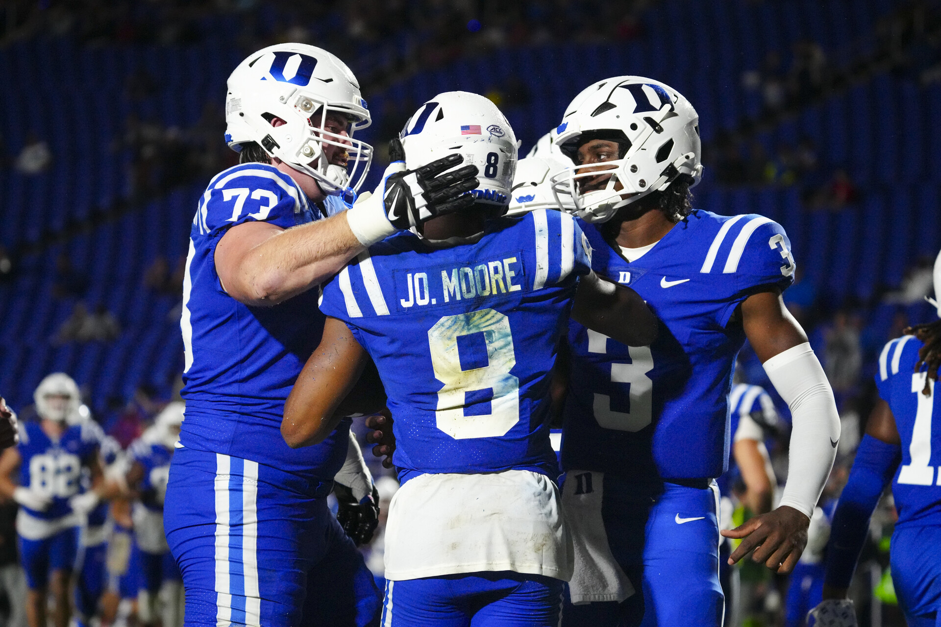 Duke Blue Devils wide receiver Jordan Moore (8) is congratulated by offensive lineman Jake Hornibrook (73) and quarterback Henry Belin IV (3) after his touchdown run against the Lafayette Leopards Duke Blue Devils punter during the second half at Wallace Wade Stadium.
