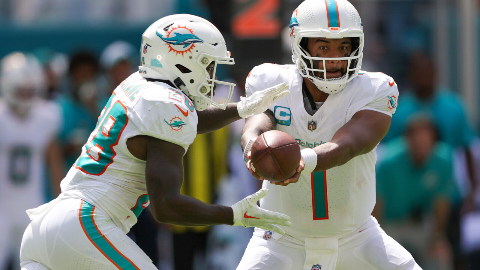 Miami Dolphins quarterback Tua Tagovailoa (1) hands off to running back De'Von Achane (28) against the Denver Broncos in the second quarter at Hard Rock Stadium.