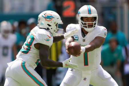 Miami Dolphins quarterback Tua Tagovailoa (1) hands off to running back De'Von Achane (28) against the Denver Broncos in the second quarter at Hard Rock Stadium.