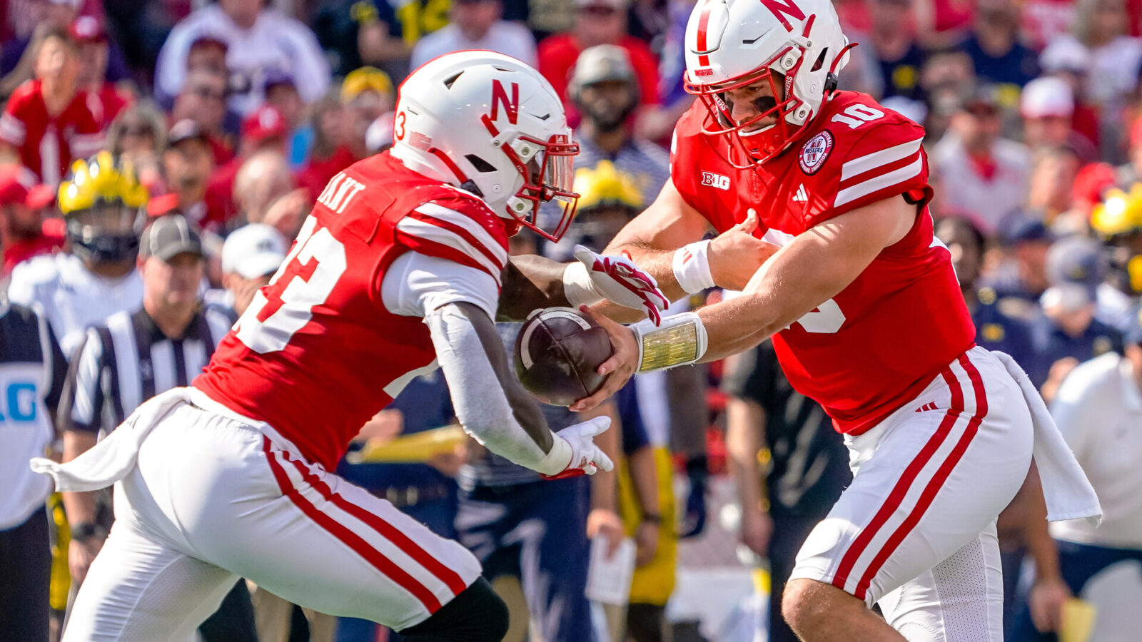 Nebraska Cornhuskers quarterback Heinrich Haarberg (10) hands the ball off to running back Anthony Grant (23) against the Michigan Wolverines during the first quarter at Memorial Stadium.