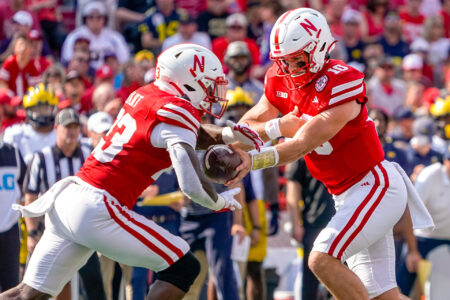 Nebraska Cornhuskers quarterback Heinrich Haarberg (10) hands the ball off to running back Anthony Grant (23) against the Michigan Wolverines during the first quarter at Memorial Stadium.