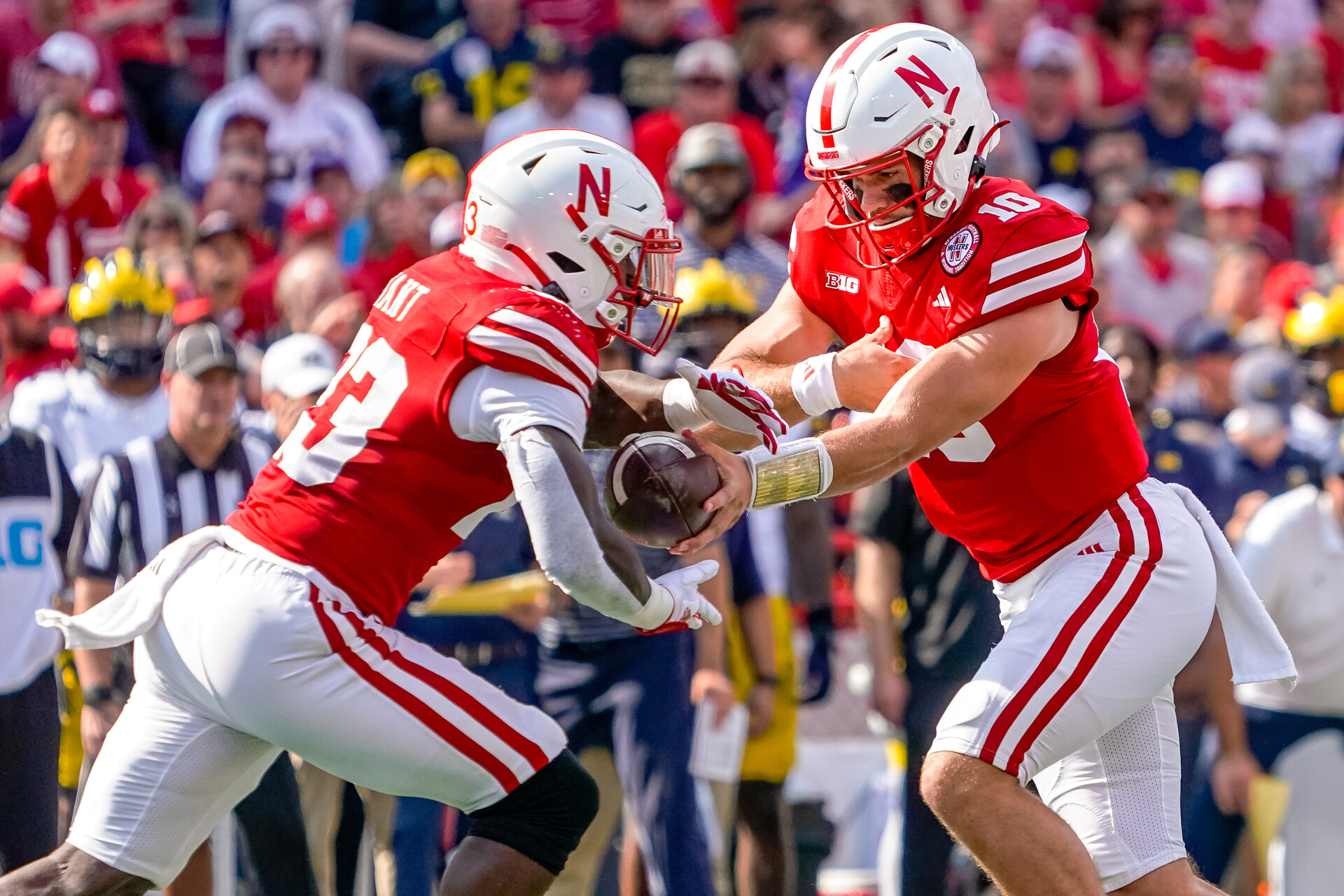 Nebraska Cornhuskers quarterback Heinrich Haarberg (10) hands the ball off to running back Anthony Grant (23) against the Michigan Wolverines during the first quarter at Memorial Stadium.