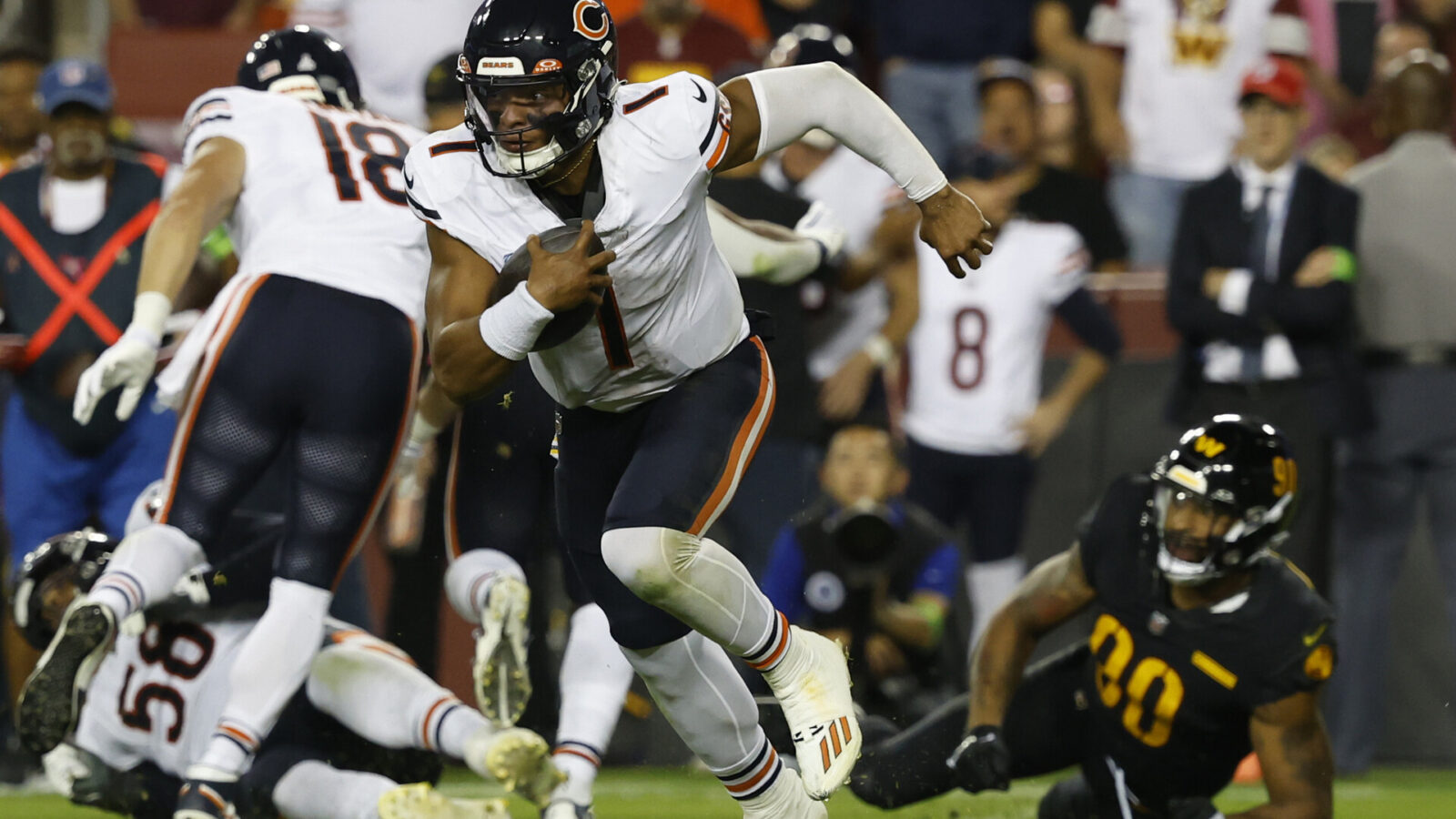 Oct 5, 2023; Landover, Maryland, USA; Chicago Bears quarterback Justin Fields (1) runs with the ball past Washington Commanders defensive end Montez Sweat (90) during the third quarter at FedExField.