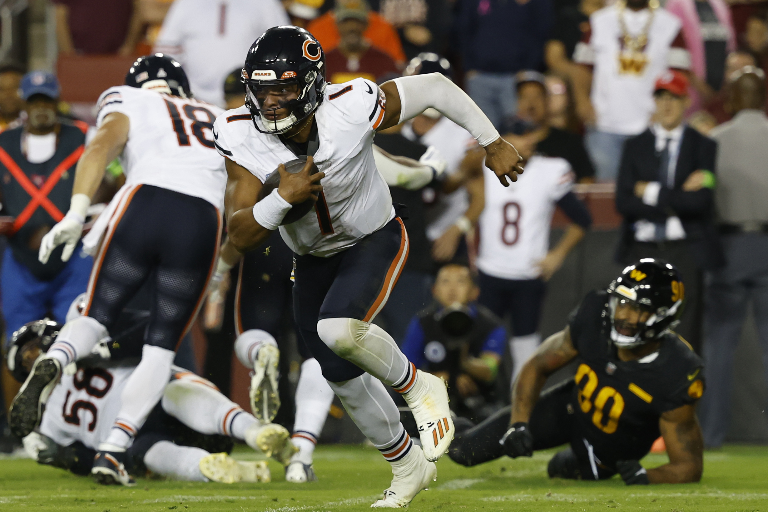 Oct 5, 2023; Landover, Maryland, USA; Chicago Bears quarterback Justin Fields (1) runs with the ball past Washington Commanders defensive end Montez Sweat (90) during the third quarter at FedExField.
