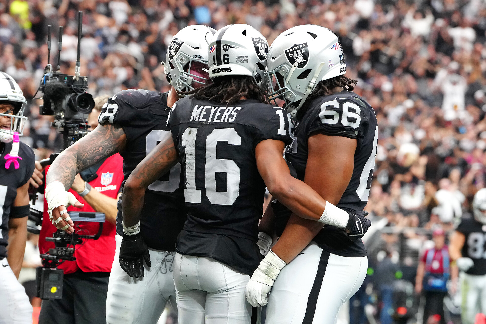 Oct 15, 2023; Paradise, Nevada, USA; Las Vegas Raiders wide receiver Jakobi Meyers (16) celebrates with team mates after scoring a touchdown against the New England Patriots during the second quarter at Allegiant Stadium.