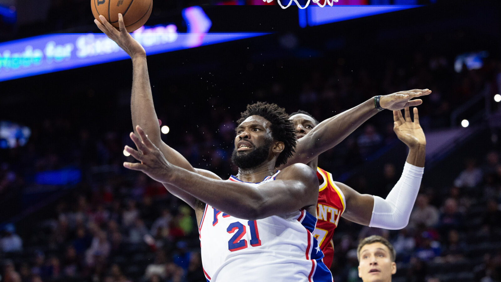 Oct 20, 2023; Philadelphia, Pennsylvania, USA; Philadelphia 76ers center Joel Embiid (21) drives for a shot past Atlanta Hawks forward Onyeka Okongwu (17) during the fourth quarter at Wells Fargo Center.