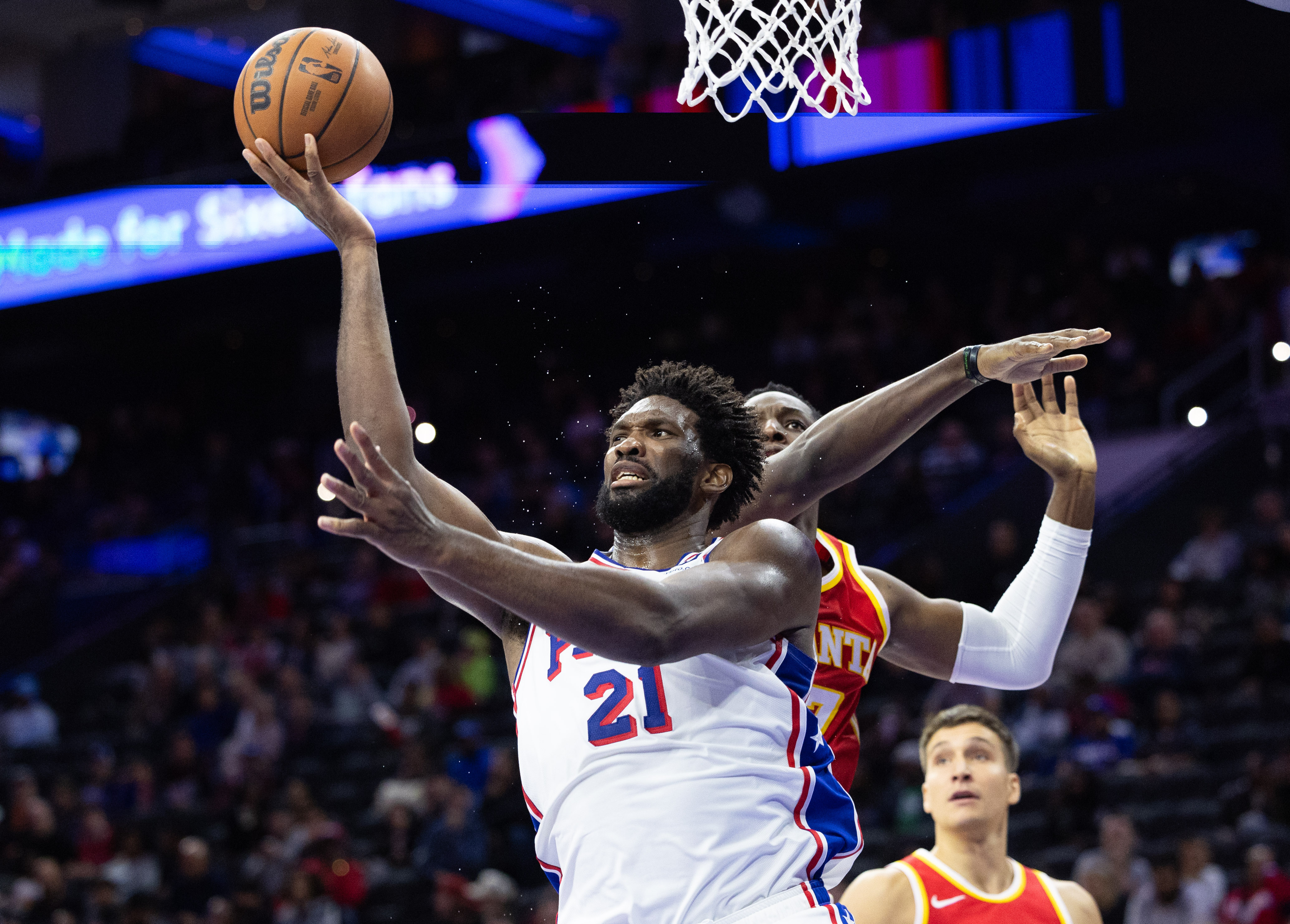 Oct 20, 2023; Philadelphia, Pennsylvania, USA; Philadelphia 76ers center Joel Embiid (21) drives for a shot past Atlanta Hawks forward Onyeka Okongwu (17) during the fourth quarter at Wells Fargo Center.