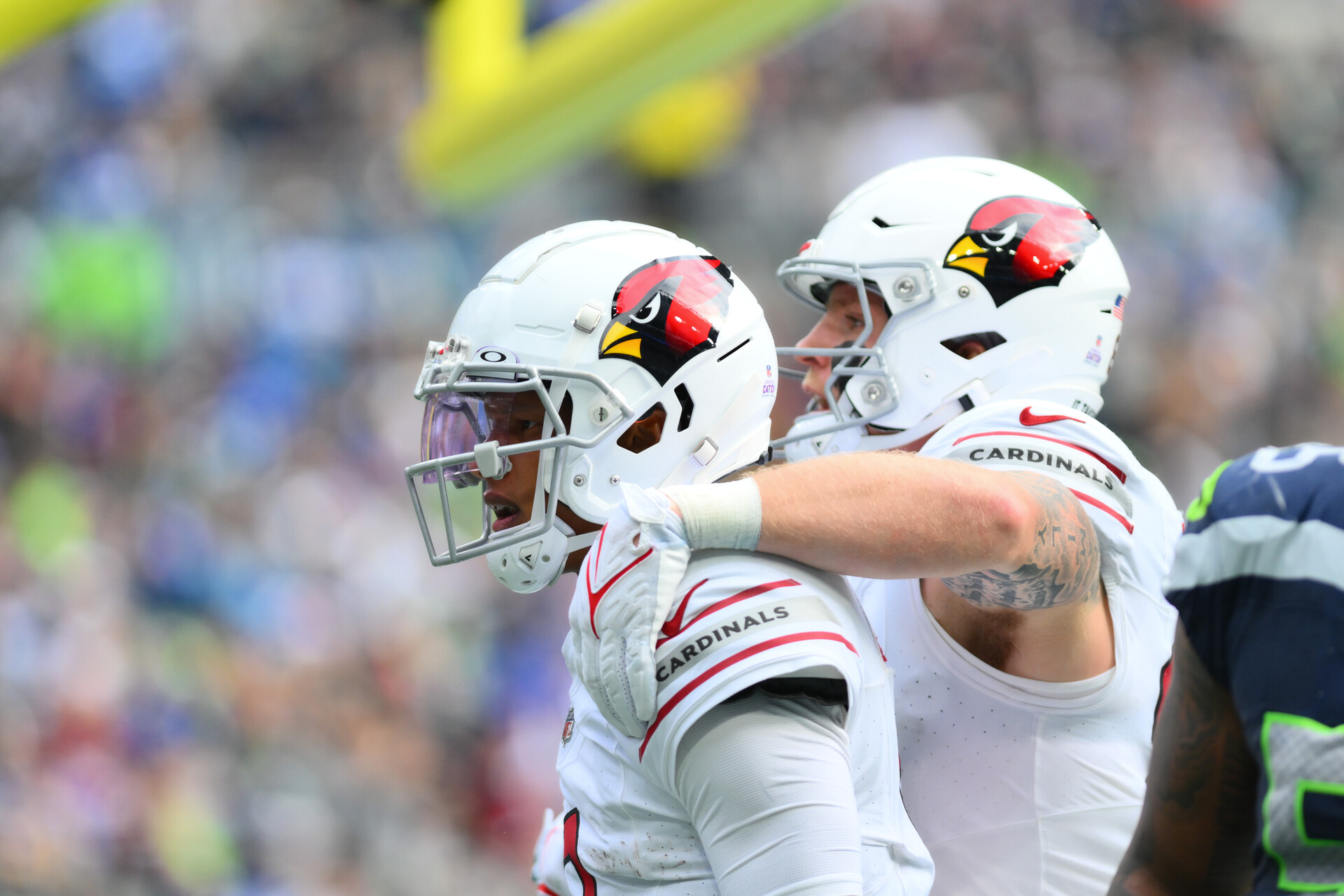 Arizona Sportsbook Promos - Arizona Cardinals Joshua Dobbs and Trey McBride on the sideline during a game