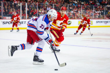 Oct 24, 2023; Calgary, Alberta, CAN; New York Rangers defenseman Adam Fox (23) skates with the puck against the Calgary Flames during the second period at Scotiabank Saddledome