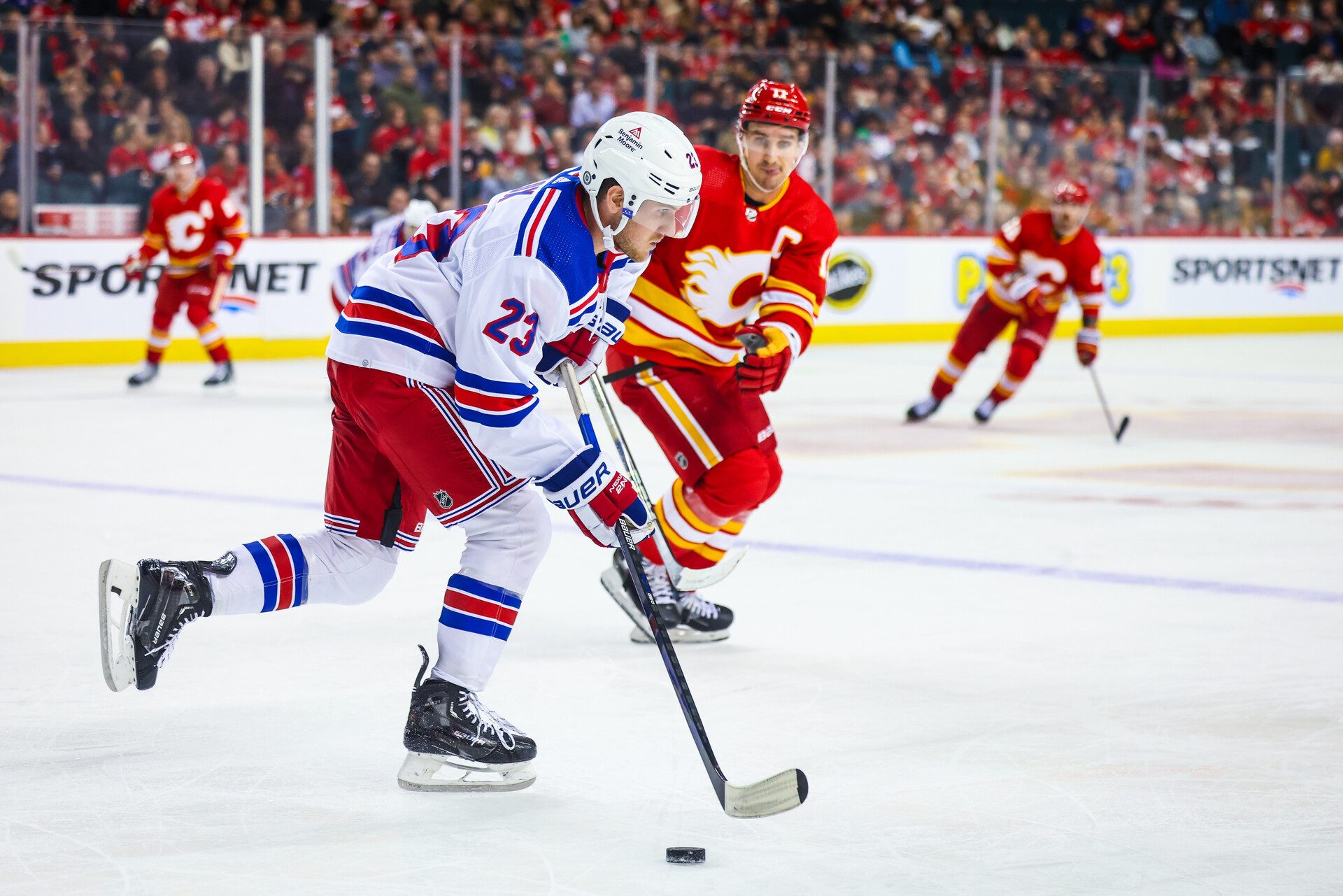 Oct 24, 2023; Calgary, Alberta, CAN; New York Rangers defenseman Adam Fox (23) skates with the puck against the Calgary Flames during the second period at Scotiabank Saddledome