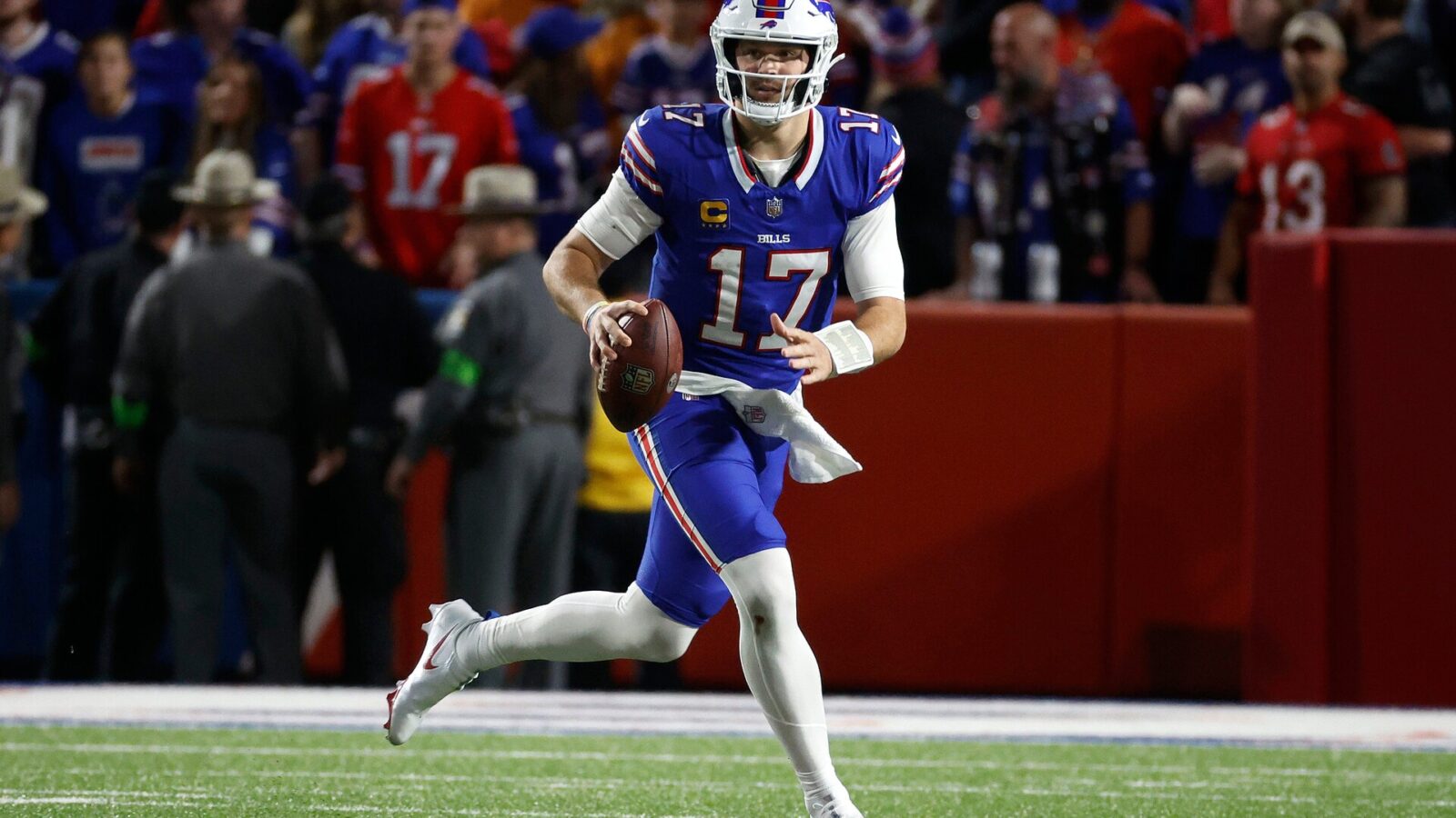 Buffalo Bills quarterback Josh Allen (17) rolls to his left as he looks downfield.