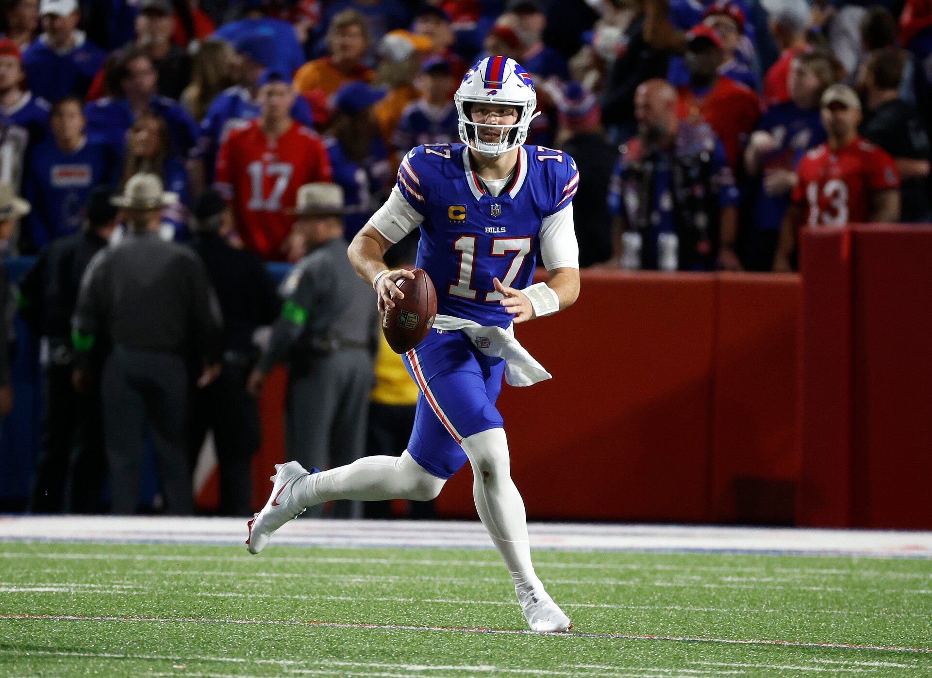 Buffalo Bills quarterback Josh Allen (17) rolls to his left as he looks downfield.