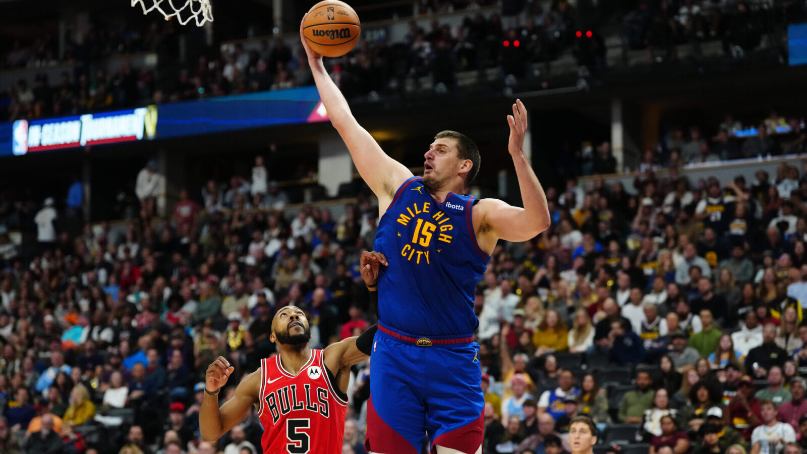 Nov 4, 2023; Denver, Colorado, USA; Denver Nuggets center Nikola Jokic (15) grabs a rebound over Chicago Bulls guard Jevon Carter (5) in the second half at Ball Arena.