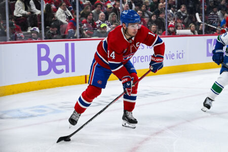 Nov 12, 2023; Montreal, Quebec, CAN; Montreal Canadiens center Nick Suzuki (14) plays the puck against the Vancouver Canucks during the second period at Bell Centre.