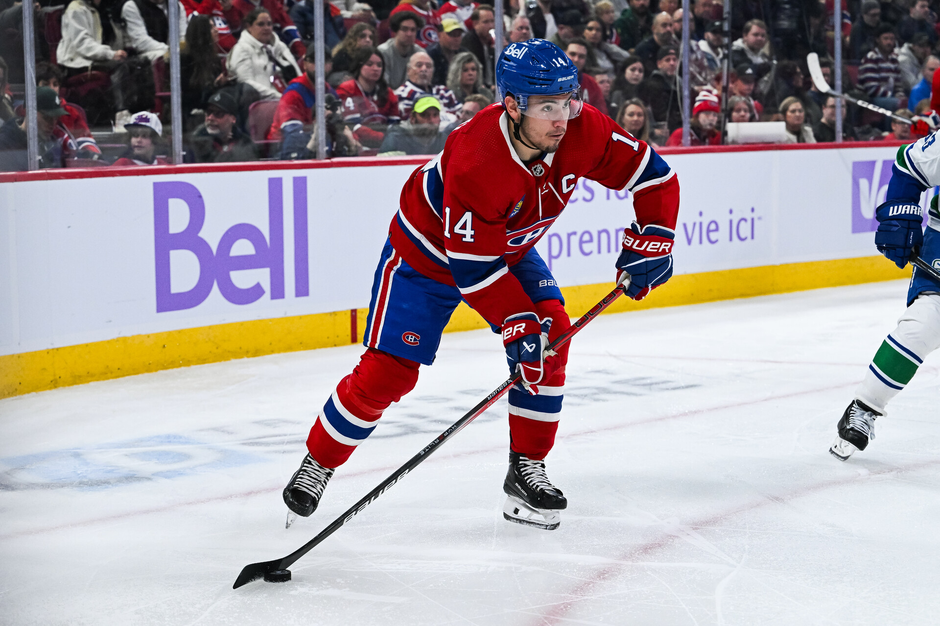 Nov 12, 2023; Montreal, Quebec, CAN; Montreal Canadiens center Nick Suzuki (14) plays the puck against the Vancouver Canucks during the second period at Bell Centre.