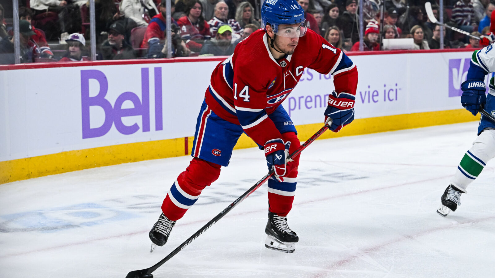 Nov 12, 2023; Montreal, Quebec, CAN; Montreal Canadiens center Nick Suzuki (14) plays the puck against the Vancouver Canucks during the second period at Bell Centre.