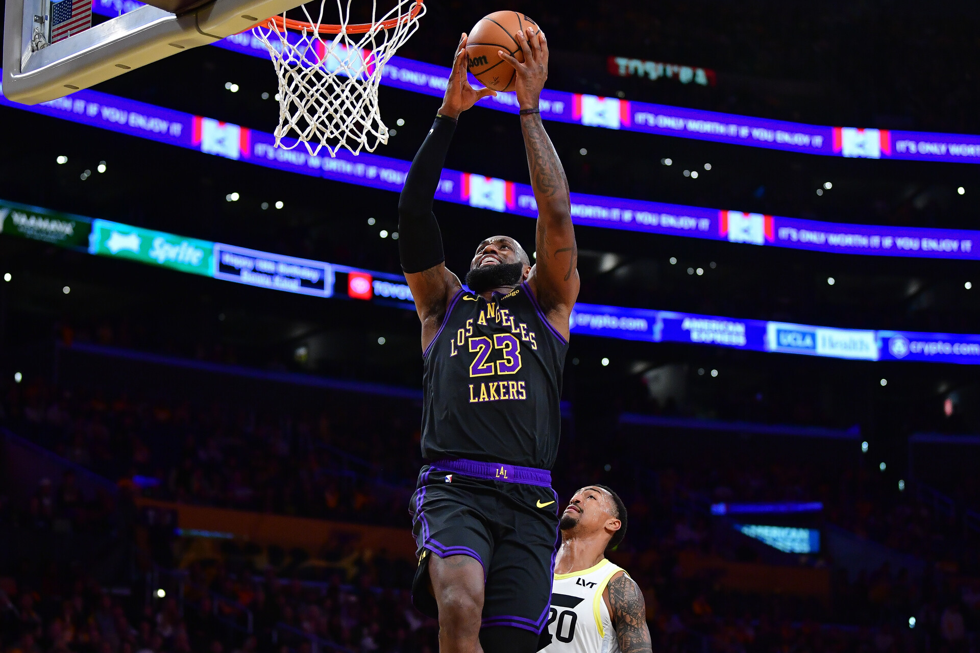 Nov 21, 2023; Los Angeles, California, USA; Los Angeles Lakers forward LeBron James (23) scores a basket ahead of Utah Jazz forward John Collins (20) during the first half at Crypto.com Arena.