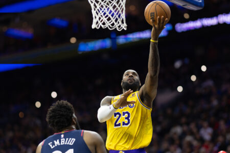 Nov 27, 2023; Philadelphia, Pennsylvania, USA; Los Angeles Lakers forward LeBron James (23) scores past Philadelphia 76ers center Joel Embiid (21) during the second quarter at Wells Fargo Center.