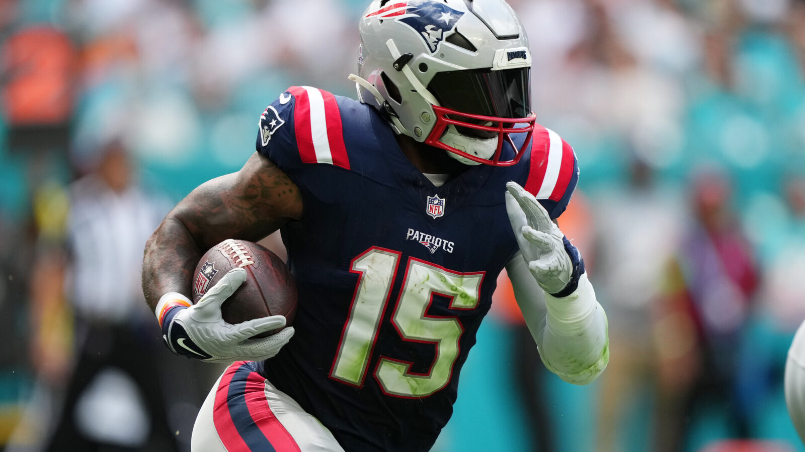 New England Patriots running back Ezekiel Elliott (15) runs the ball against the Miami Dolphins during the first half at Hard Rock Stadium.