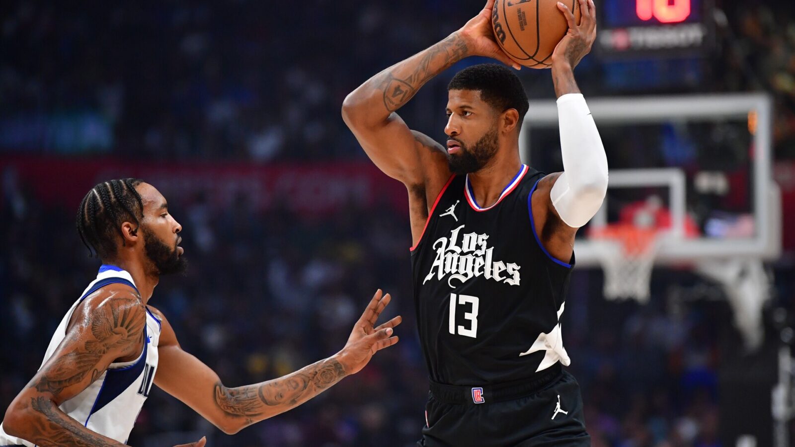 Nov 25, 2023; Los Angeles, California, USA; Los Angeles Clippers forward Paul George (13) controls the ball against Dallas Mavericks forward Derrick Jones Jr. (55) during the first half at Crypto.com Arena.