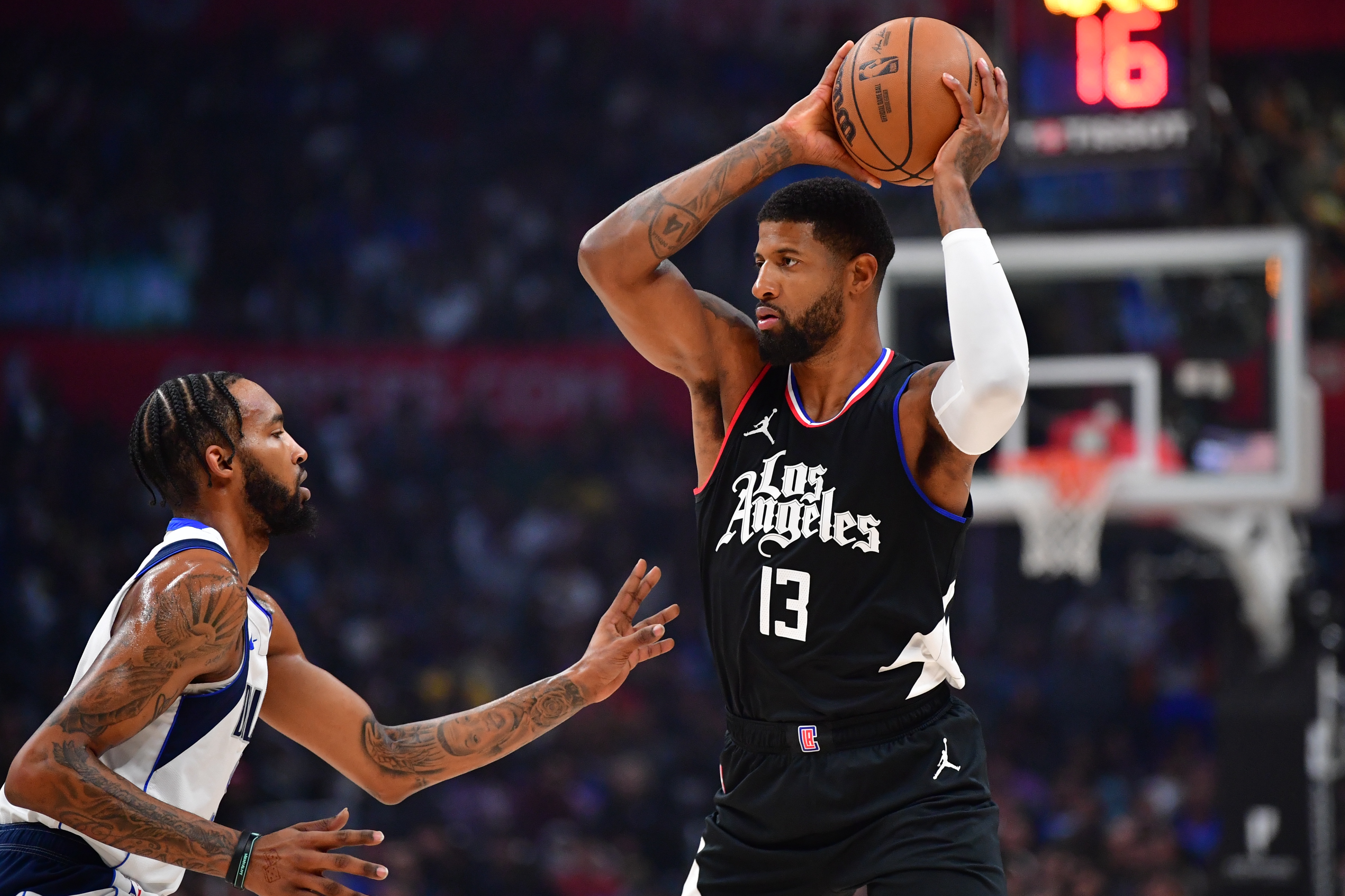 Nov 25, 2023; Los Angeles, California, USA; Los Angeles Clippers forward Paul George (13) controls the ball against Dallas Mavericks forward Derrick Jones Jr. (55) during the first half at Crypto.com Arena.
