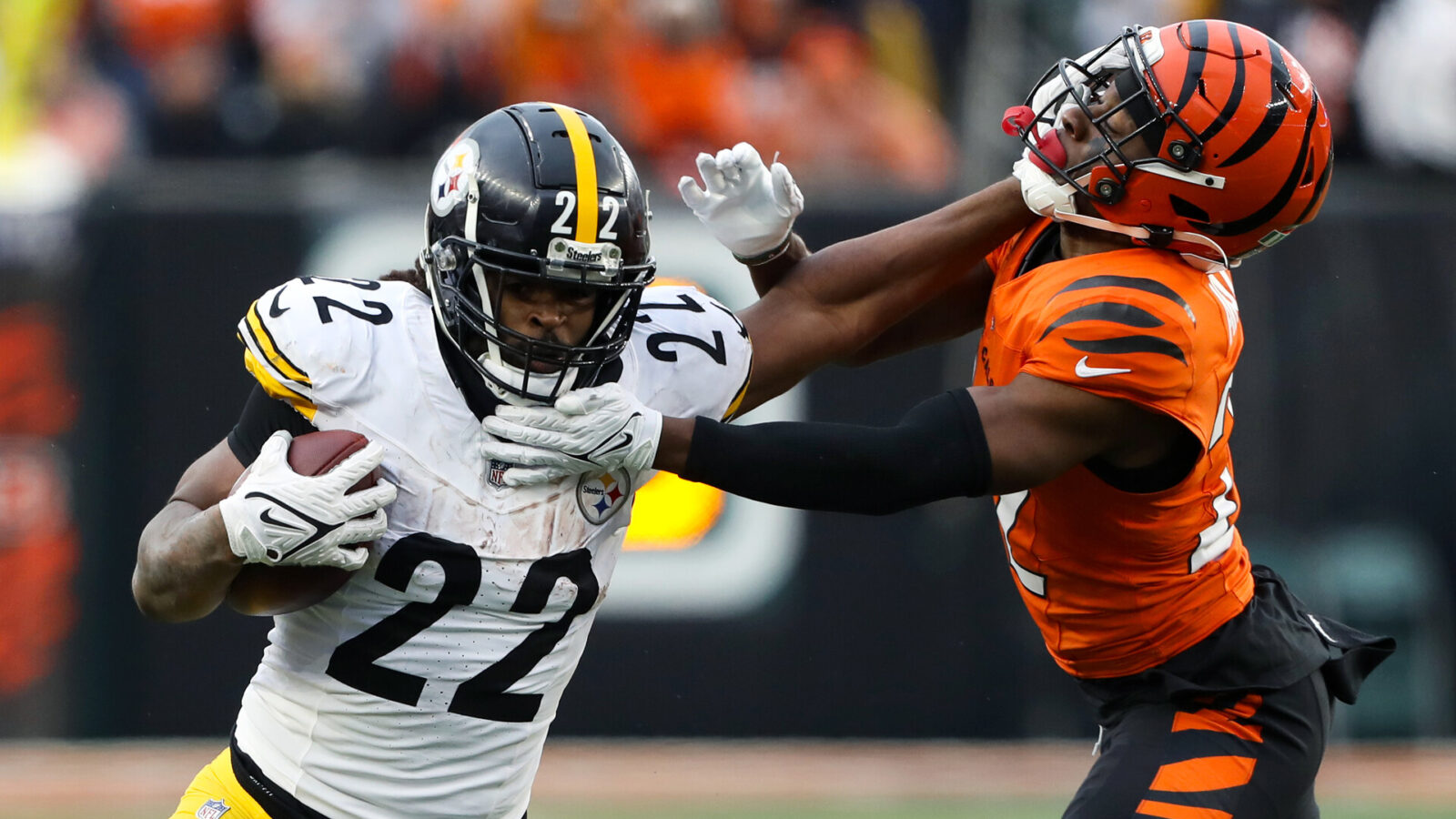 Nov 26, 2023; Cincinnati, Ohio, USA; Pittsburgh Steelers running back Najee Harris (22) fends off Cincinnati Bengals cornerback Chidobe Awuzie (22) during the fourth quarter at Paycor Stadium.