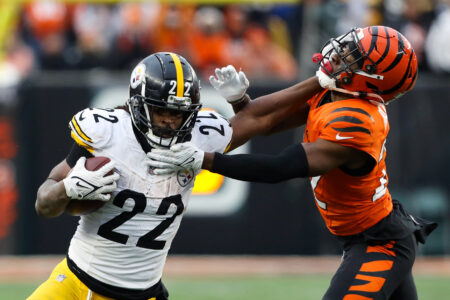 Nov 26, 2023; Cincinnati, Ohio, USA; Pittsburgh Steelers running back Najee Harris (22) fends off Cincinnati Bengals cornerback Chidobe Awuzie (22) during the fourth quarter at Paycor Stadium.