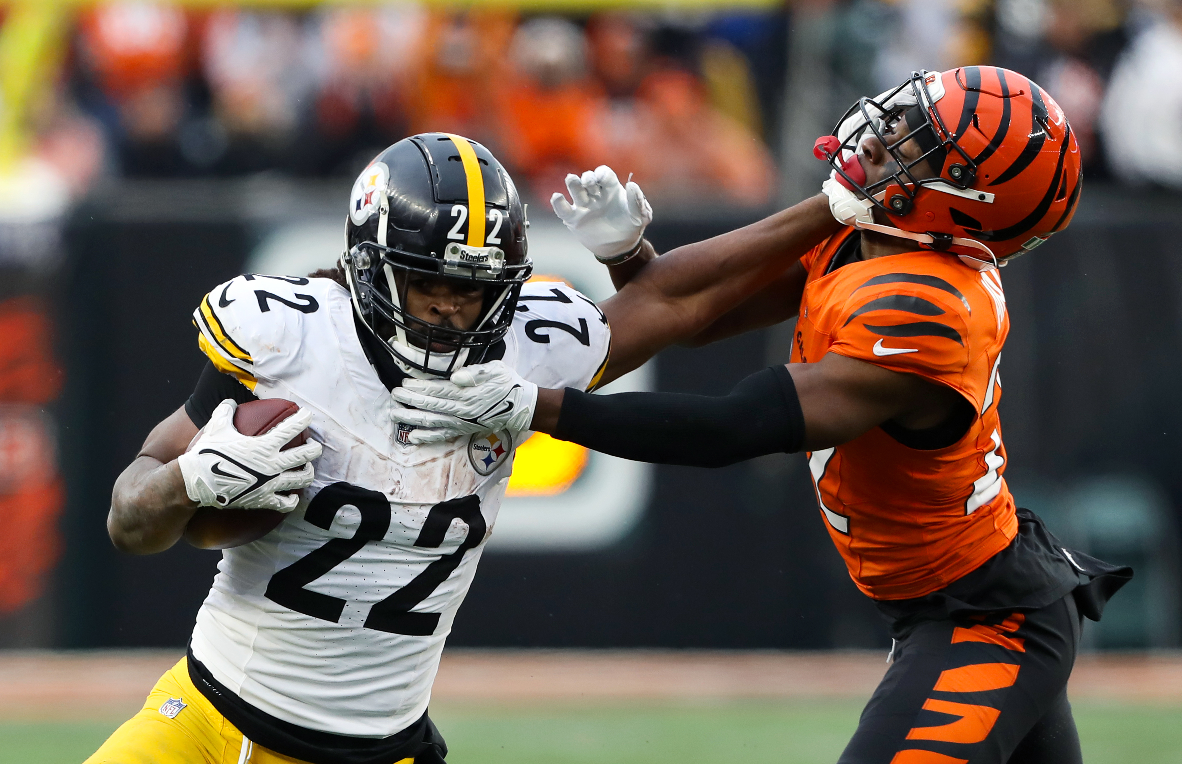 Nov 26, 2023; Cincinnati, Ohio, USA; Pittsburgh Steelers running back Najee Harris (22) fends off Cincinnati Bengals cornerback Chidobe Awuzie (22) during the fourth quarter at Paycor Stadium.