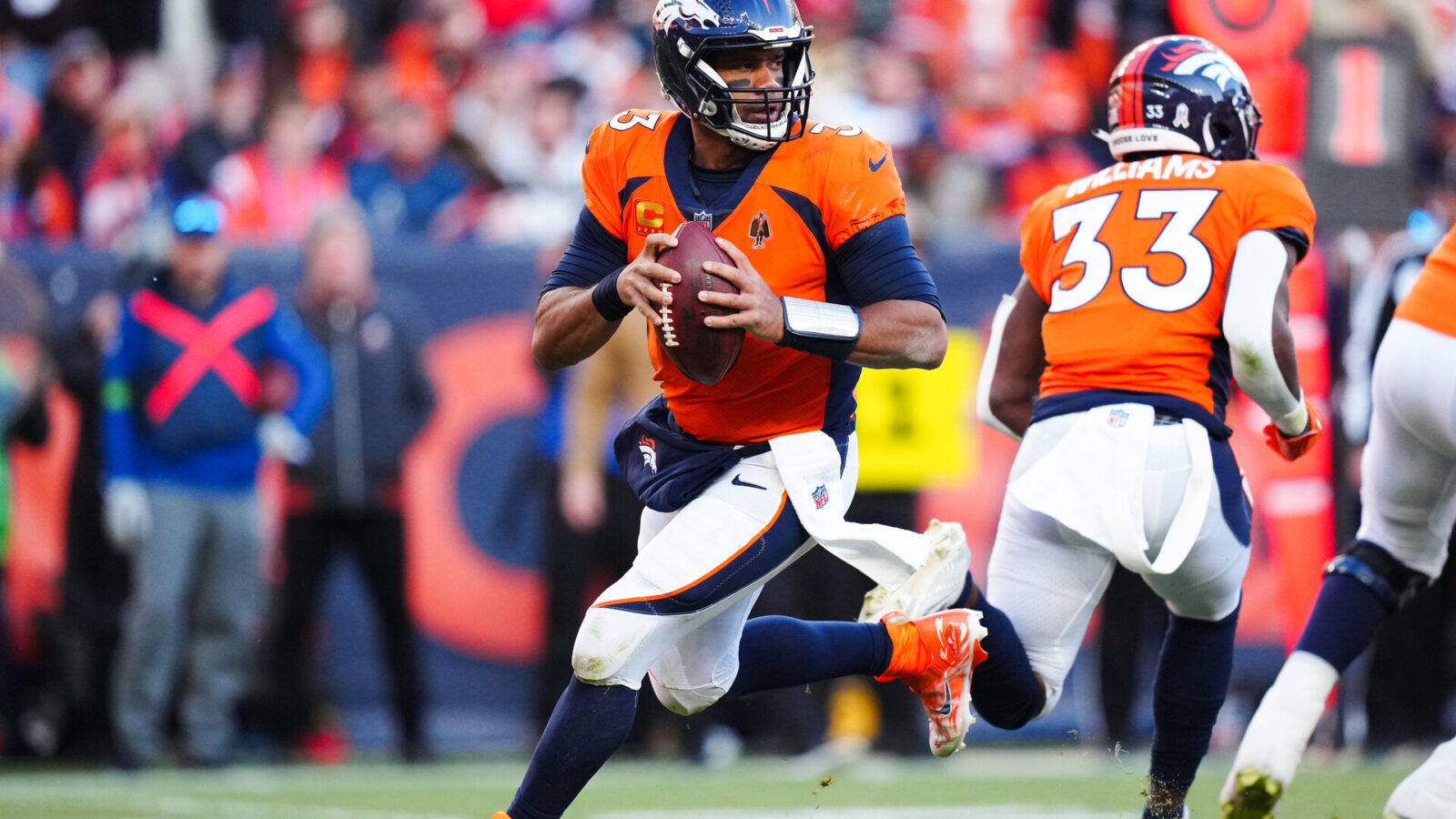 Nov 26, 2023; Denver, Colorado, USA; Denver Broncos quarterback Russell Wilson (3) scrambles in the first half against the Cleveland Browns at Empower Field at Mile High.