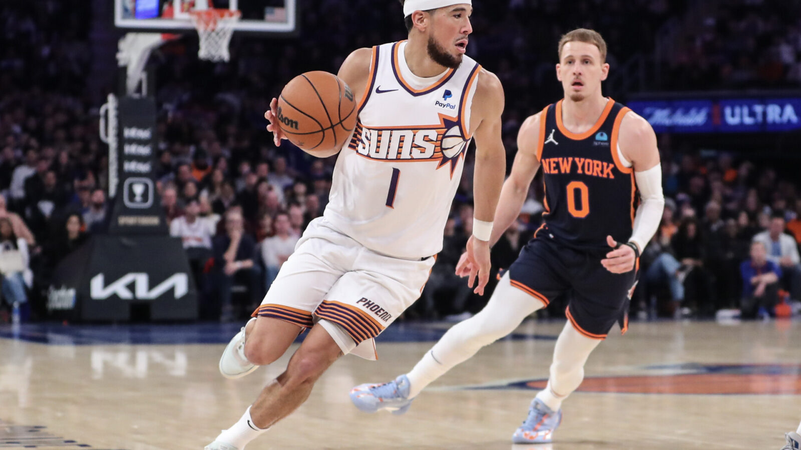 Nov 26, 2023; New York, New York, USA; Phoenix Suns guard Devin Booker (1) drives past New York Knicks guard Donte DiVincenzo (0) in the second quarter at Madison Square Garden.