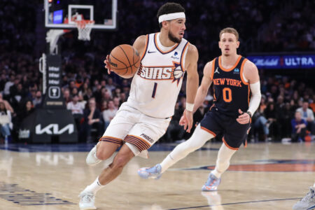 Nov 26, 2023; New York, New York, USA; Phoenix Suns guard Devin Booker (1) drives past New York Knicks guard Donte DiVincenzo (0) in the second quarter at Madison Square Garden.