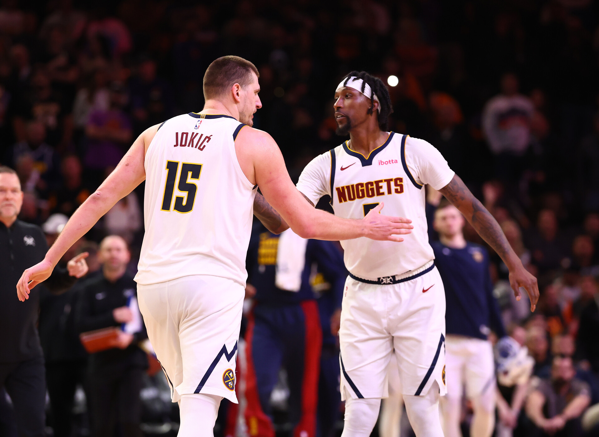 Dec 1, 2023; Phoenix, Arizona, USA; Denver Nuggets center Nikola Jokic (15) celebrates with guard Kentavious Caldwell-Pope (5) against the Phoenix Suns in the second half at Footprint Center.