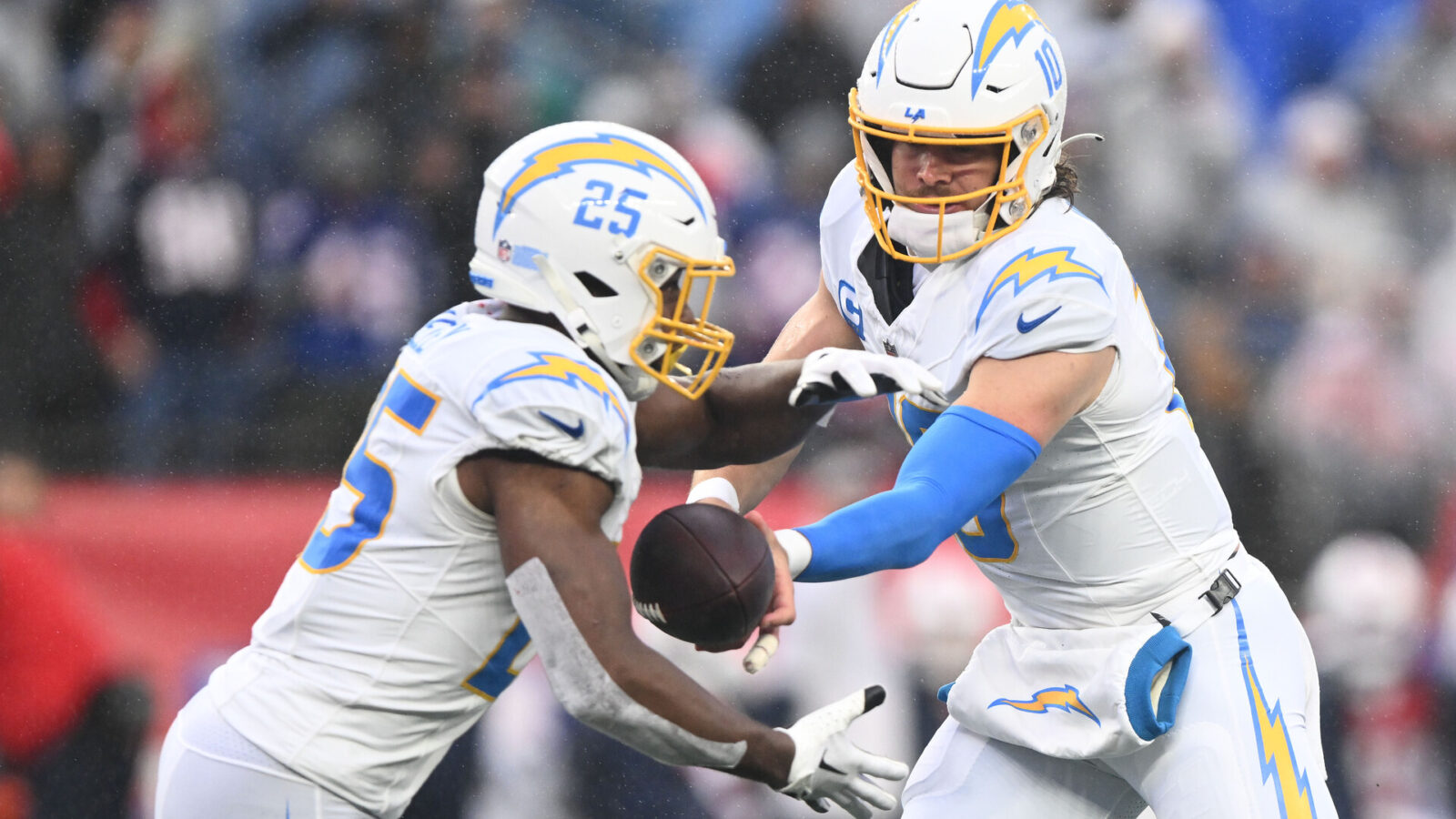 Dec 3, 2023; Foxborough, Massachusetts, USA; Los Angeles Chargers quarterback Justin Herbert (10) hands the ball off to running back Joshua Kelley (25) during the first half of a game against the New England Patriots at Gillette Stadium.