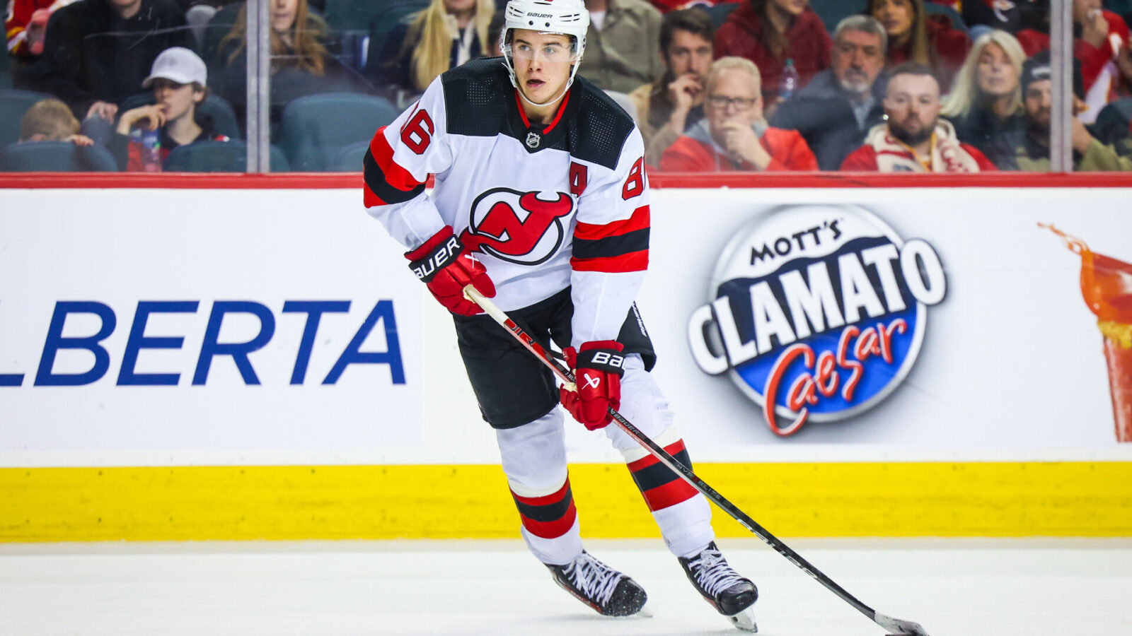 Dec 9, 2023; Calgary, Alberta, CAN; New Jersey Devils center Jack Hughes (86) skates with the puck against the Calgary Flames during the third period at Scotiabank Saddledome.
