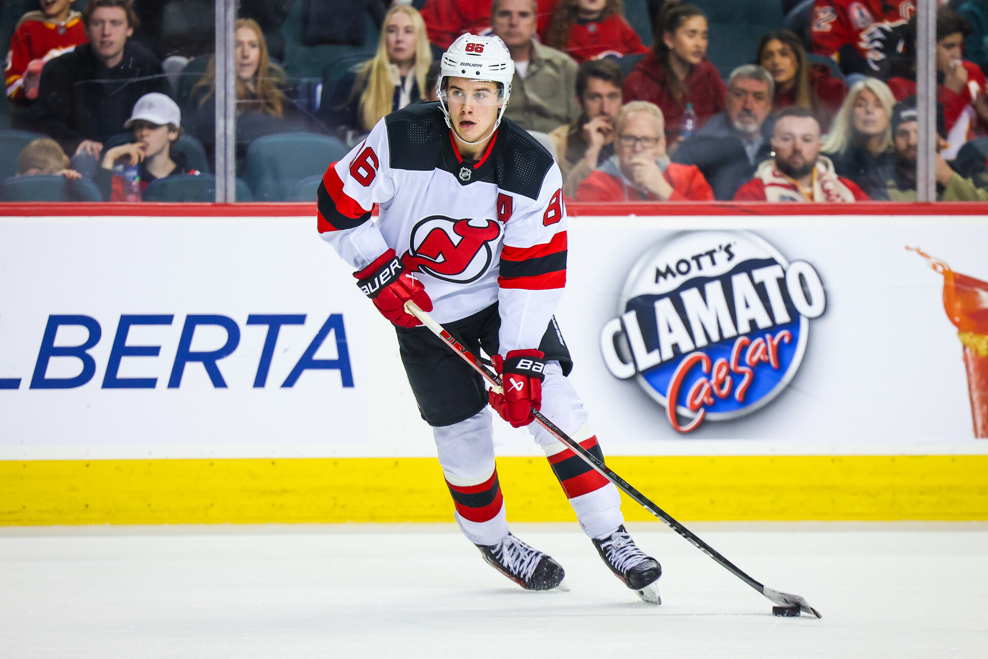 Dec 9, 2023; Calgary, Alberta, CAN; New Jersey Devils center Jack Hughes (86) skates with the puck against the Calgary Flames during the third period at Scotiabank Saddledome.