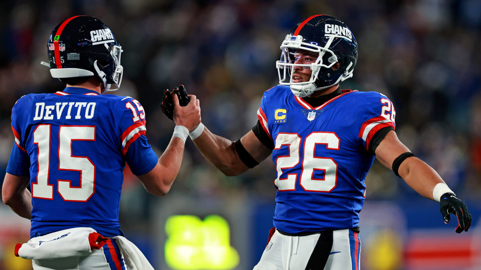 New York Giants running back Saquon Barkley (26) celebrates with quarterback Tommy DeVito (15) after scoring a touchdown during the third quarter against the Green Bay Packers at MetLife Stadium.
