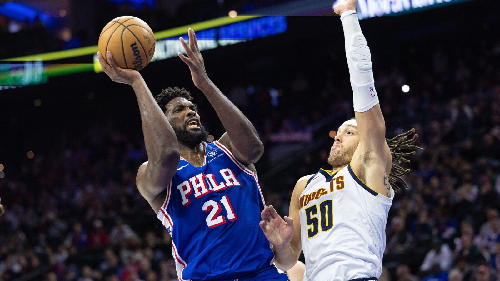 Jan 16, 2024; Philadelphia, Pennsylvania, USA; Philadelphia 76ers center Joel Embiid (21) drives for a shot against Denver Nuggets forward Aaron Gordon (50) during the fourth quarter at Wells Fargo Center.