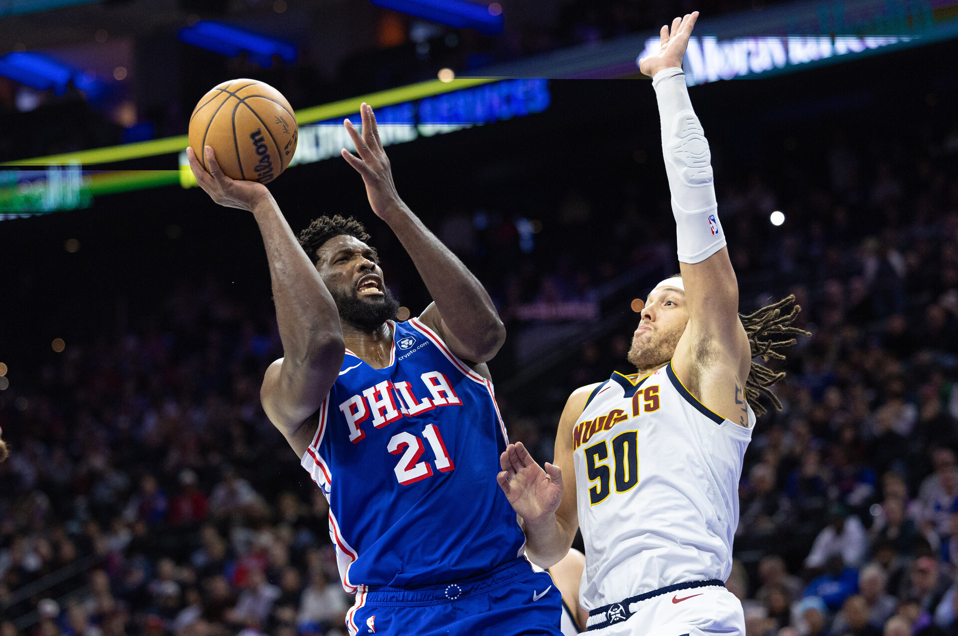 Jan 16, 2024; Philadelphia, Pennsylvania, USA; Philadelphia 76ers center Joel Embiid (21) drives for a shot against Denver Nuggets forward Aaron Gordon (50) during the fourth quarter at Wells Fargo Center.
