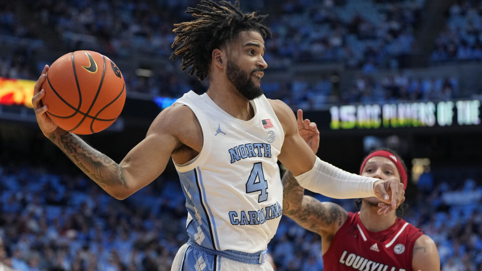 North Carolina Tar Heels guard RJ Davis (4) passes the ball as Louisville Cardinals guard Tre White (22) defends in the second half at Dean E. Smith Center.