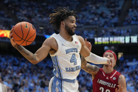 North Carolina Tar Heels guard RJ Davis (4) passes the ball as Louisville Cardinals guard Tre White (22) defends in the second half at Dean E. Smith Center.