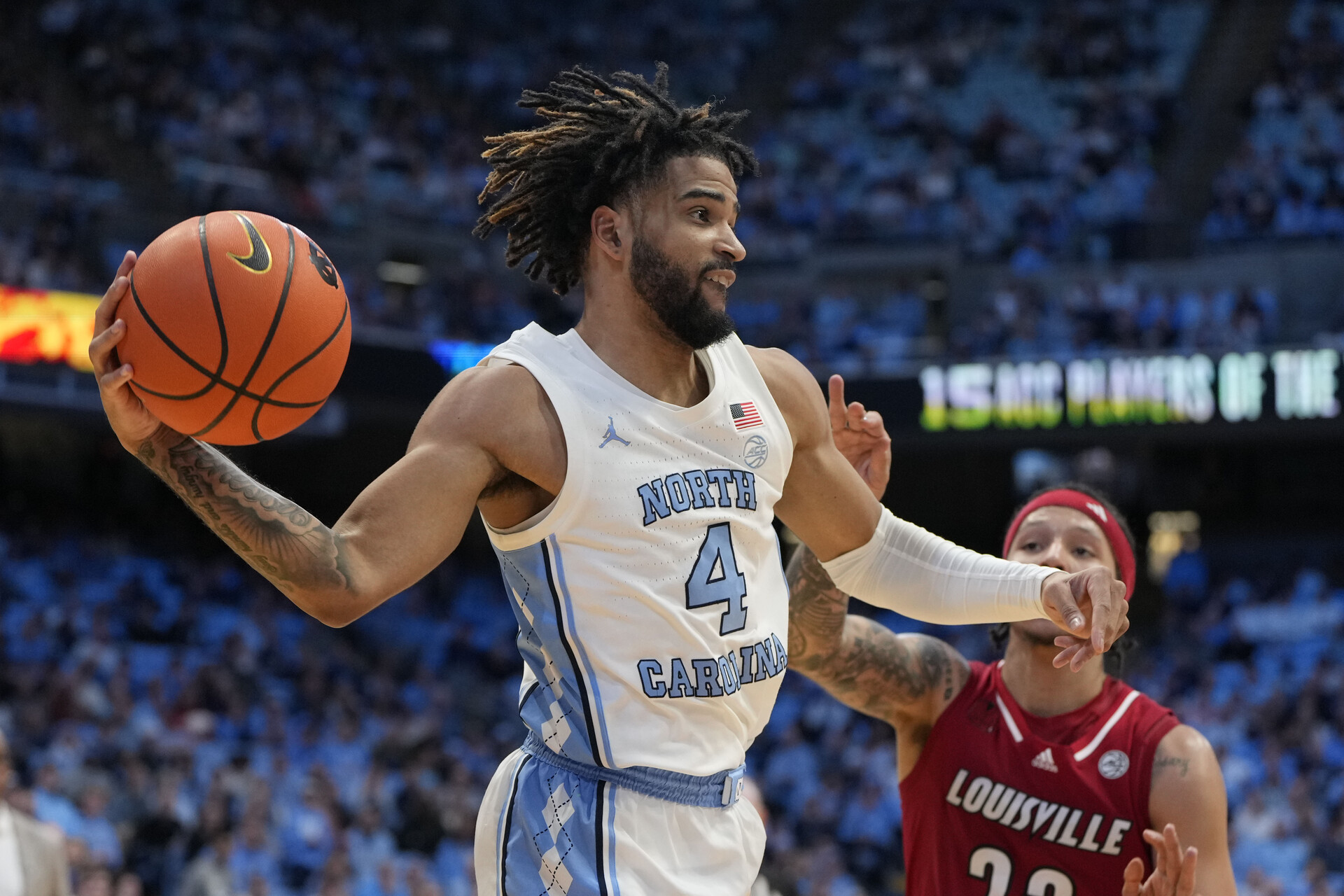 North Carolina Tar Heels guard RJ Davis (4) passes the ball as Louisville Cardinals guard Tre White (22) defends in the second half at Dean E. Smith Center.