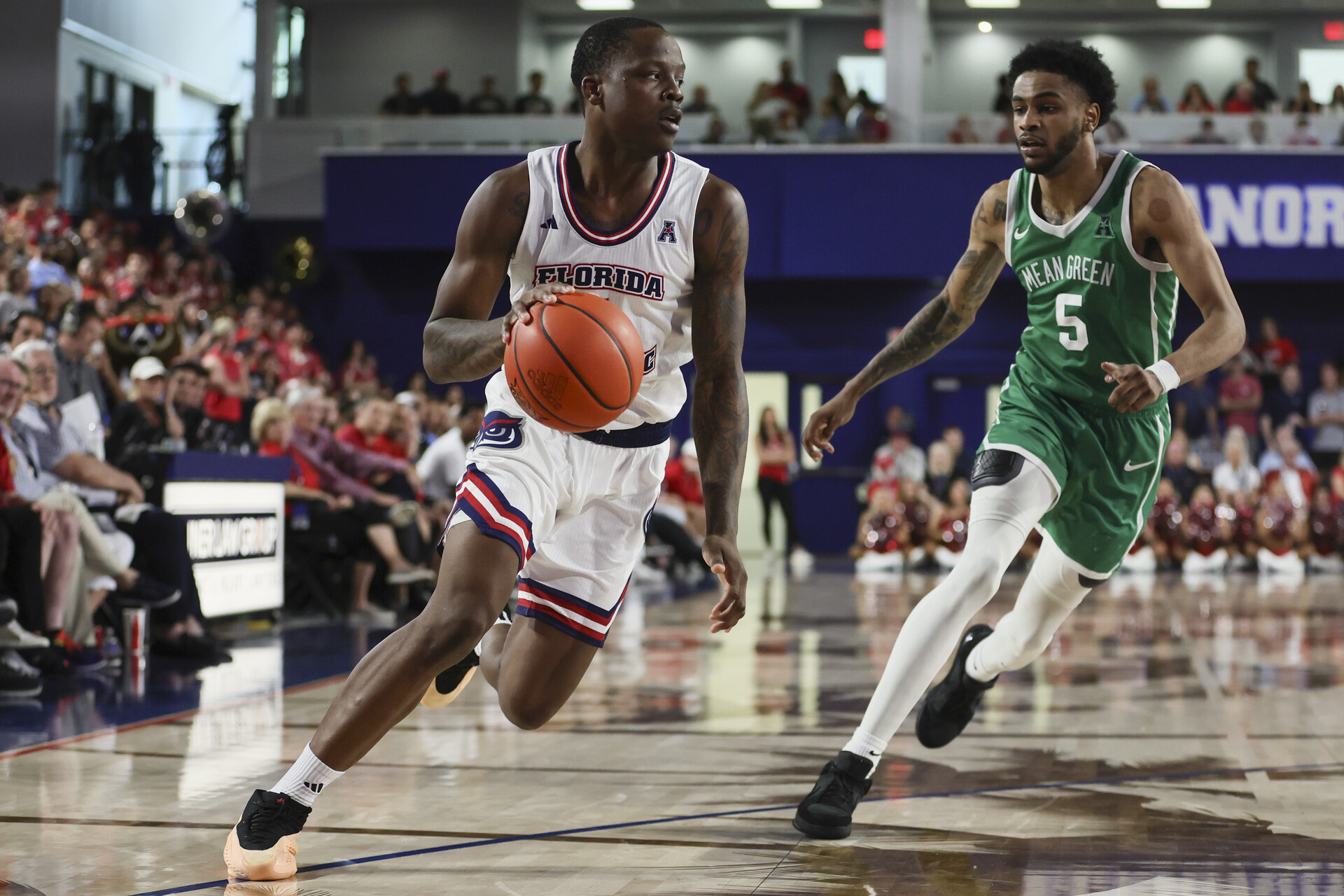 Jan 28, 2024; Boca Raton, Florida, USA; Florida Atlantic Owls guard Johnell Davis (1) drives to the basket past North Texas Mean Green guard Rondel Walker (5) during the second half at Eleanor R. Baldwin Arena