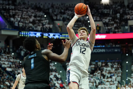 Feb 17, 2024; Hartford, Connecticut, USA; UConn Huskies guard Cam Spencer (12) shoots against Marquette Golden Eagles guard Kam Jones (1) in the second half at XL Cente