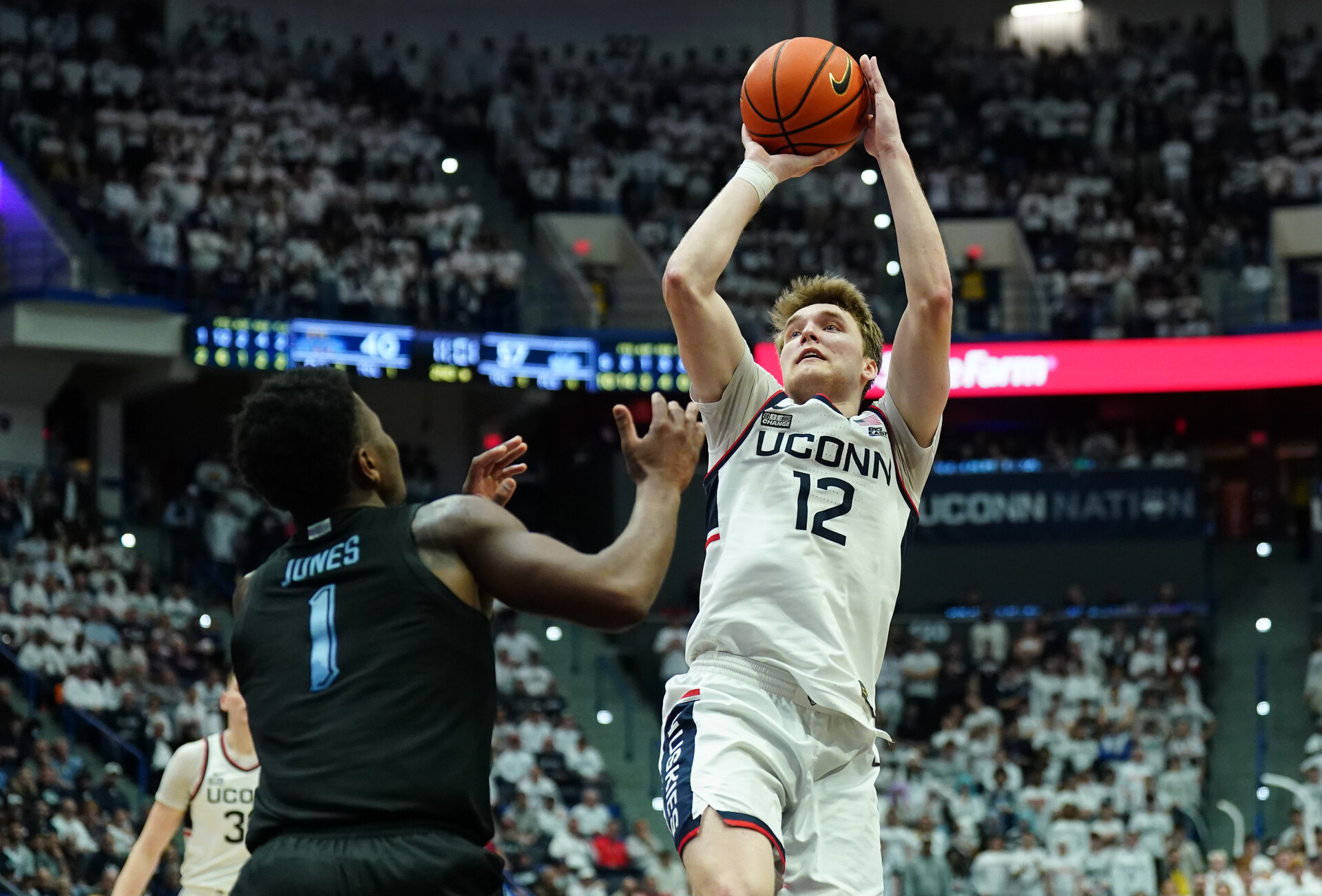 Feb 17, 2024; Hartford, Connecticut, USA; UConn Huskies guard Cam Spencer (12) shoots against Marquette Golden Eagles guard Kam Jones (1) in the second half at XL Cente