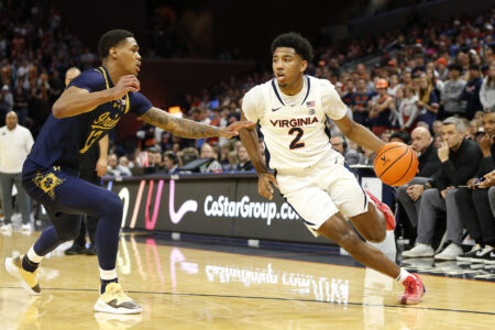Jan 31, 2024; Charlottesville, Virginia, USA; Virginia Cavaliers guard Reece Beekman (2) dribbles the ball as Notre Dame Fighting Irish forward Tae Davis (13) defends during the second half at John Paul Jones Arena.