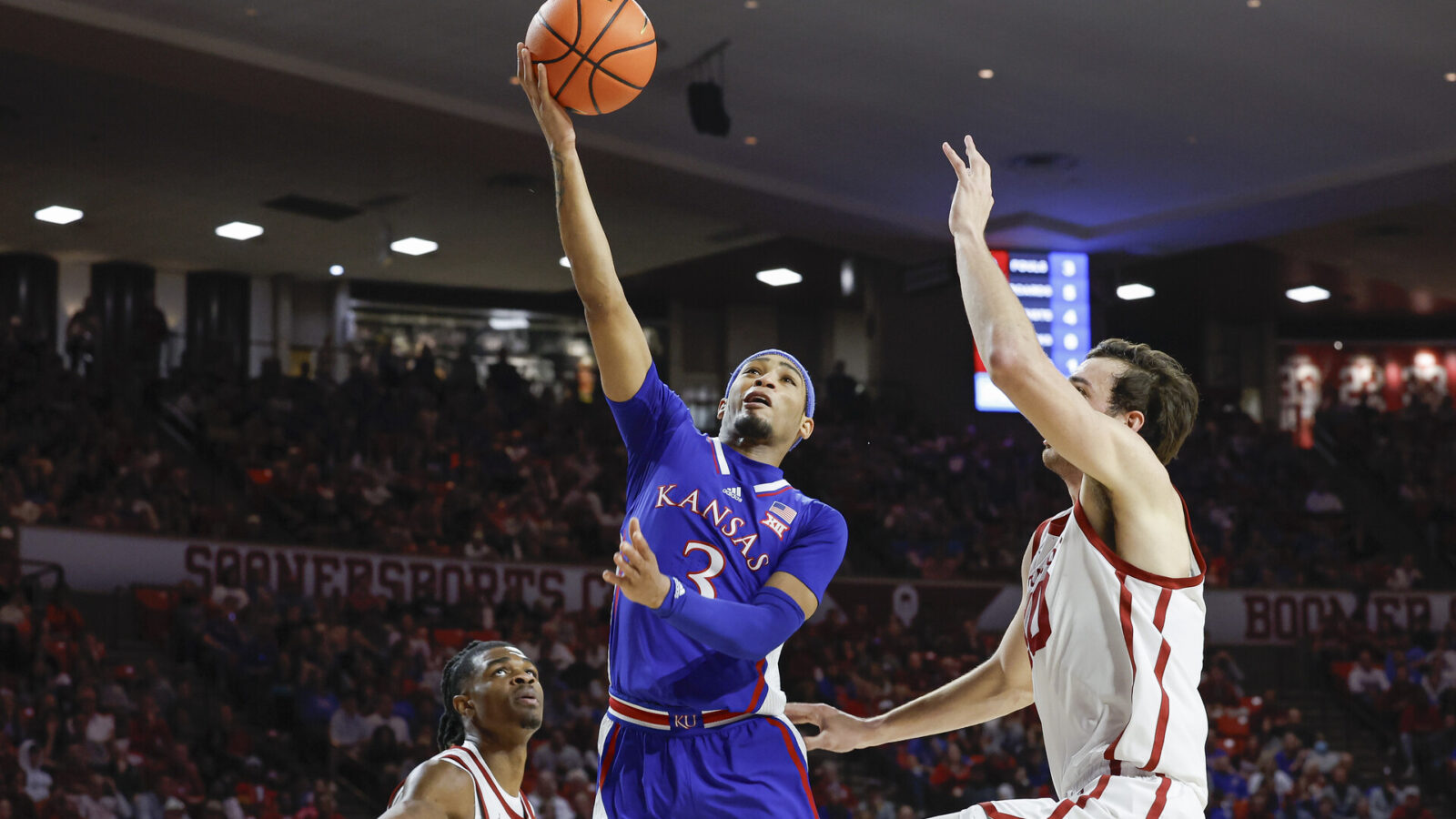 Feb 17, 2024; Norman, Oklahoma, USA; Kansas Jayhawks guard Dajuan Harris Jr. (3) shoots beside Oklahoma Sooners forward Sam Godwin (10) during the first half at Lloyd Noble Center.