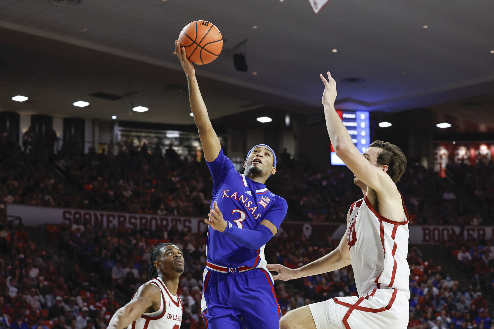 Feb 17, 2024; Norman, Oklahoma, USA; Kansas Jayhawks guard Dajuan Harris Jr. (3) shoots beside Oklahoma Sooners forward Sam Godwin (10) during the first half at Lloyd Noble Center.
