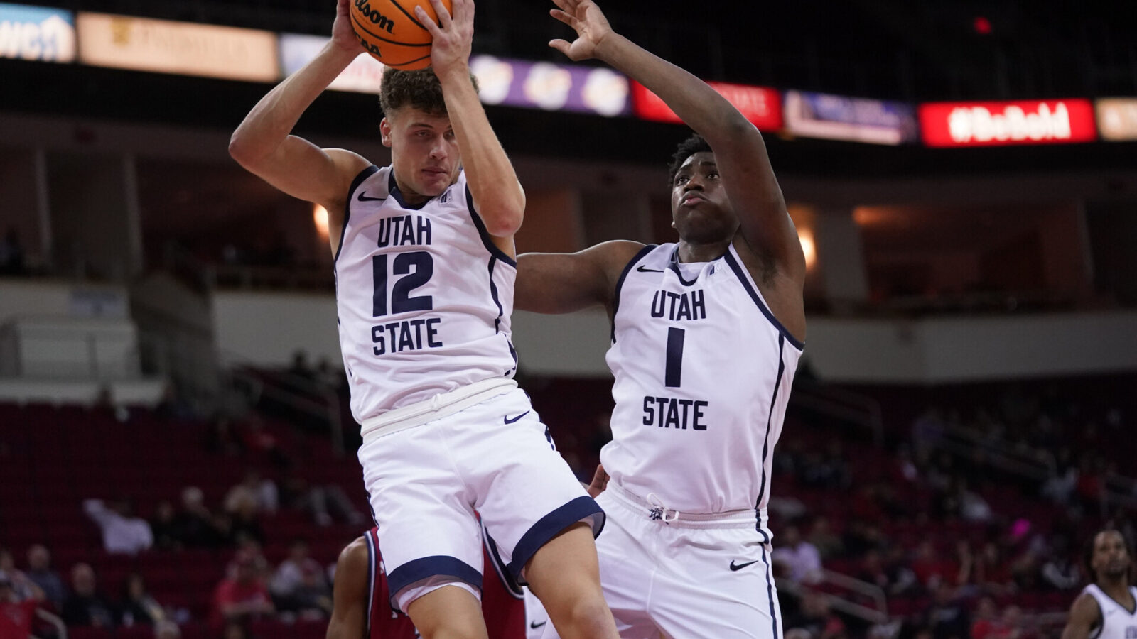 Feb 27, 2024; Fresno, California, USA; Utah State Aggies guard Mason Falslev (12) holds onto a rebound next to forward Great Osobor (1) against the Fresno State Bulldogs in the second half at the Save Mart Center.