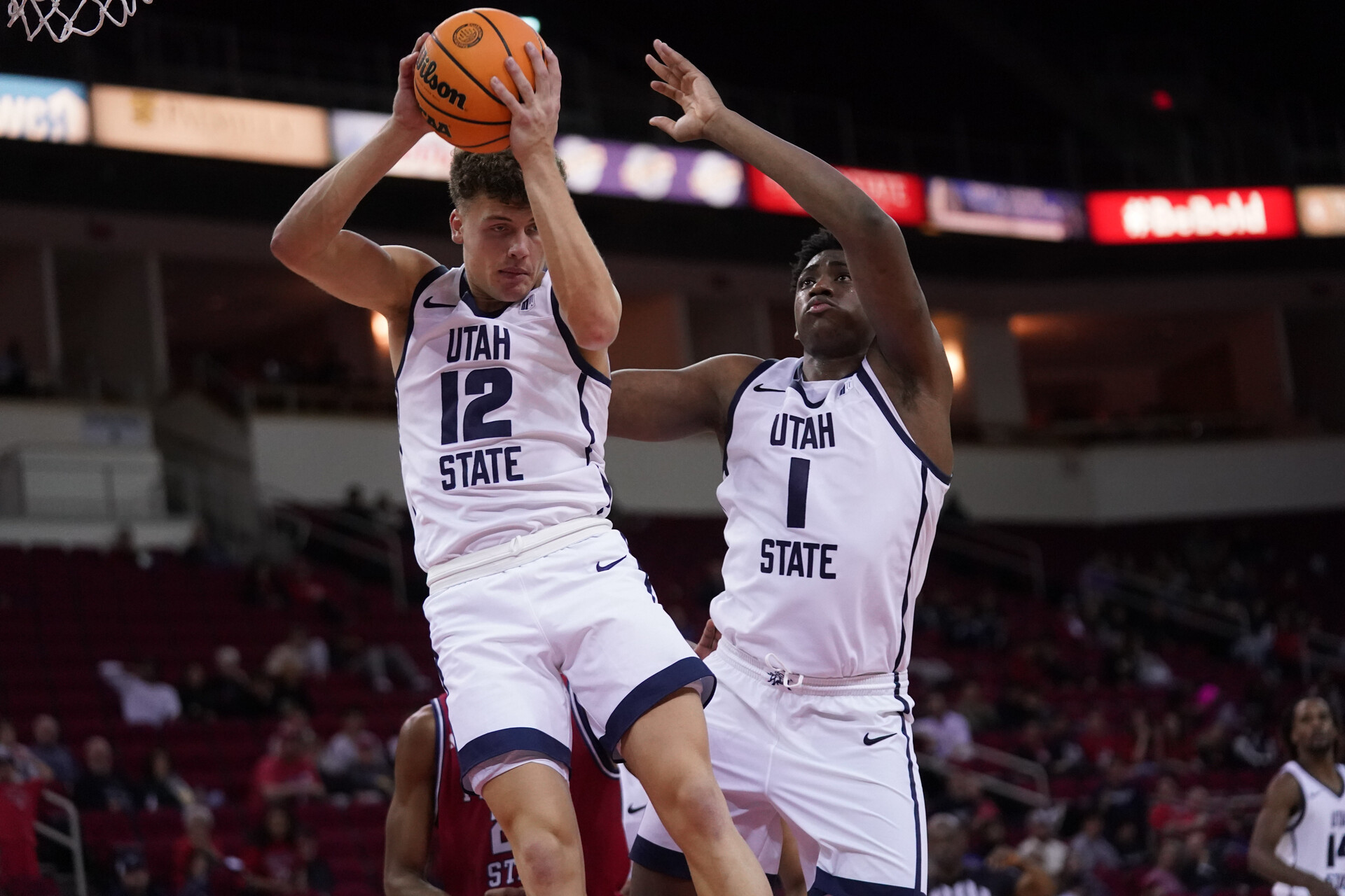 Feb 27, 2024; Fresno, California, USA; Utah State Aggies guard Mason Falslev (12) holds onto a rebound next to forward Great Osobor (1) against the Fresno State Bulldogs in the second half at the Save Mart Center.