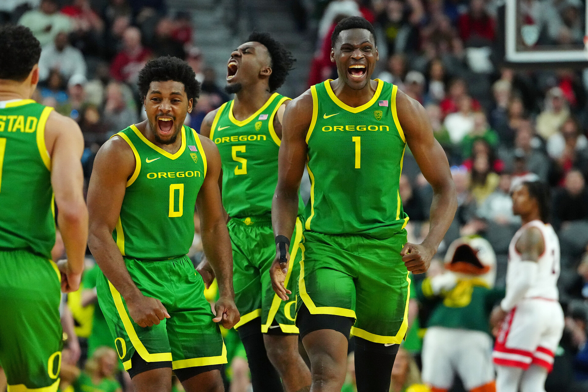 Mar 15, 2024; Las Vegas, NV, USA; Oregon Ducks center N'Faly Dante (1) celebrates with Oregon Ducks guard Kario Oquendo (0), and Oregon Ducks guard Jermaine Couisnard (5) after making a play against the Arizona Wildcats during the second half at T-Mobile Arena.
